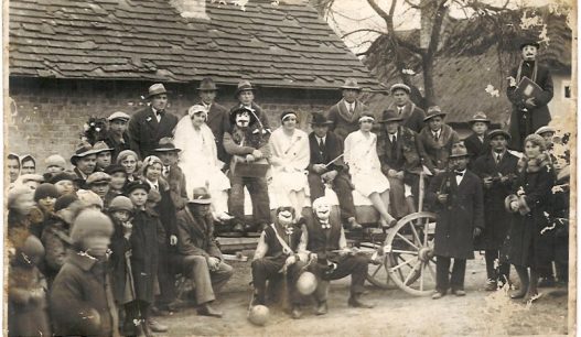 Vordergrund: 2 maskierte Männer mit Schweinsblase