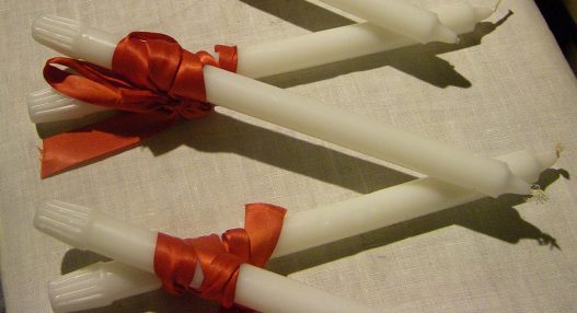Gekreuzte Kerzen mit rotem Seidenband